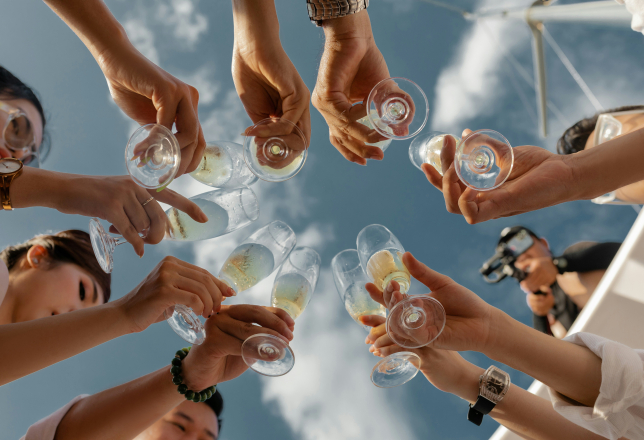 Foto van onderaf handen glazen blauwe lucht